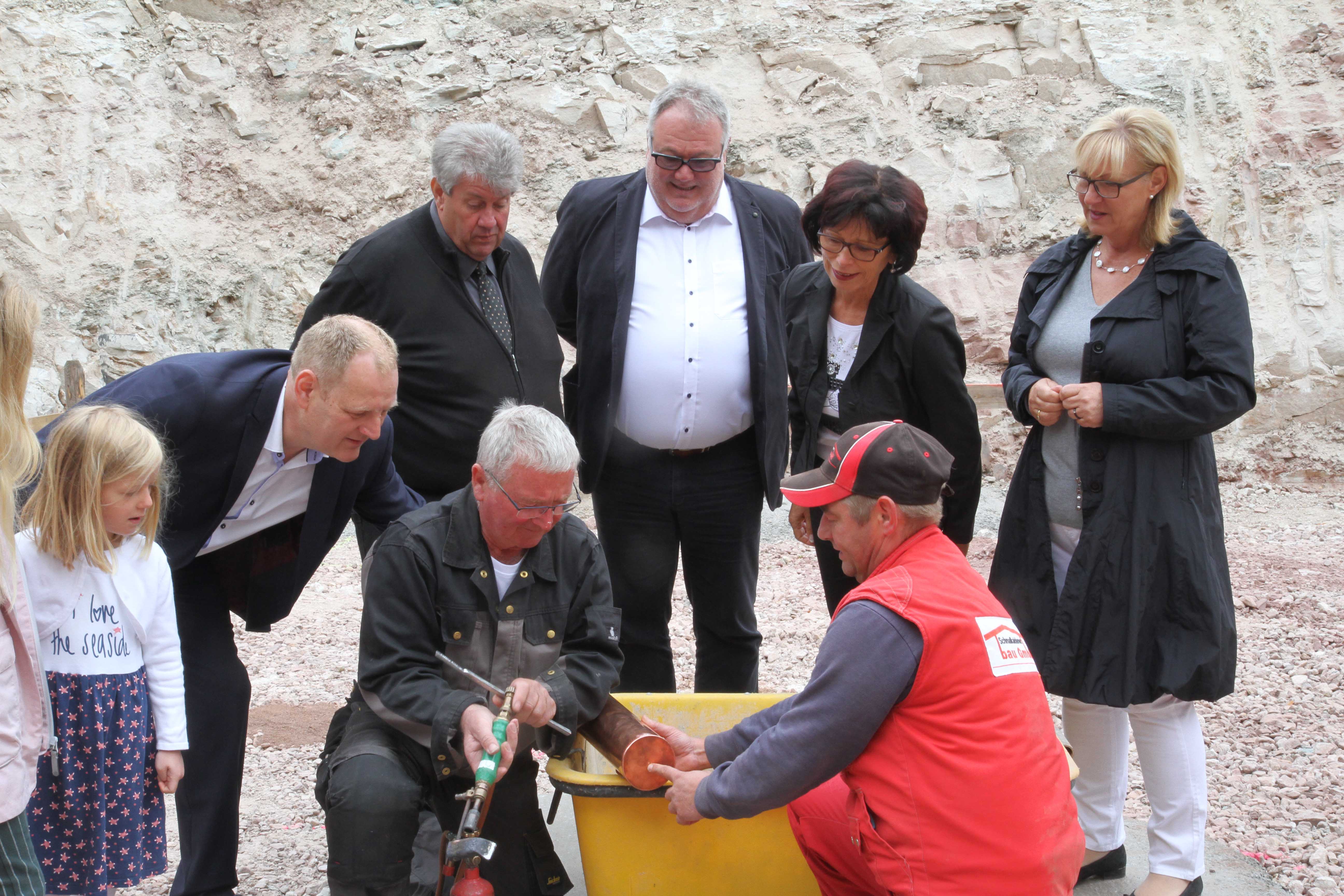 Architekt Michael Heß, Bürgermeister Thomas Klöppel, AWO AJS-Geschäftsführer Michael Hack, Petra Köllner-Hack, Geschäftsführerin der AWO-Soziale Dienste gGmbH Gotha und Kita-Leiterin Ute Biedermann-Krauß sehen gespannt beim Verlöten der Hülse zu.